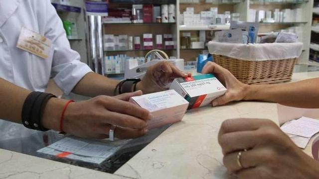 Una farmacéutica dispensa varios medicamentos.