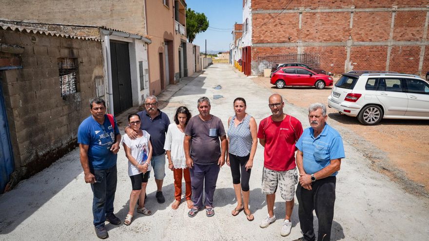 Vecinos de la barriada de Llera en Badajoz costean el asfaltado de la calle en la que viven