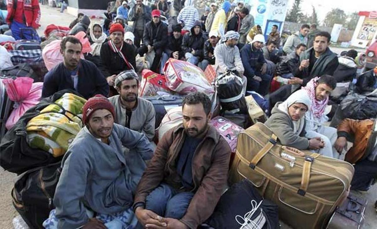 Un grup de refugiats esperen amb les seves pertinences en en el pas fronterer de Ras al-Khedir, a Tunísia. Milers de tunisians i ciutadans d’altres nacionalitats abandonen Líbia per aquest punt fronterer. Un grup de refugiats esperen amb les seves pertinences en en el pas fronterer de Ras al-Khedir, a Tunísia. Milers de tunisians i ciutadans d’altres nacionalitats abandonen Líbia per aquest punt fronterer.