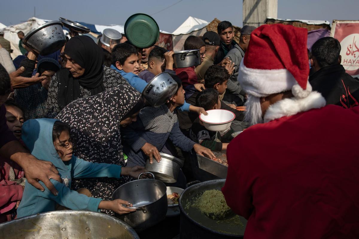 Un hombre vestido de Papá Noel reparte comida a los gazatíes en Jan Yunis