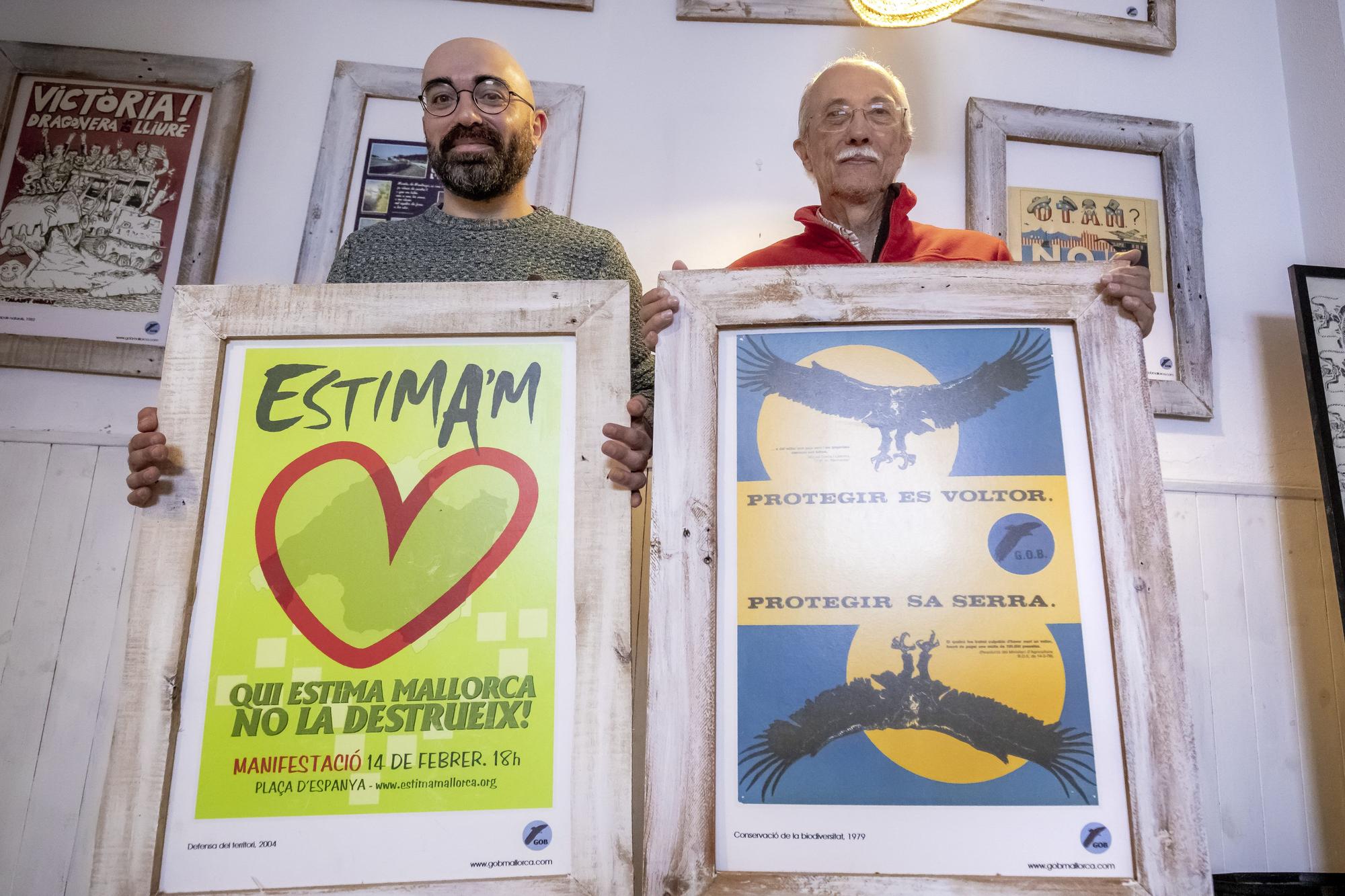 Amadeu Corbera y Miquel Rayó sostienen dos carteles que recuerdan dos hitos del GOB.