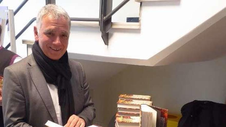 Juan Ramón Lucas con ejemplares de su libro, en Noreña.