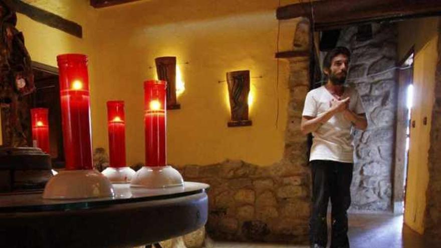 Sánchez Heras, en el vestíbulo de la antigua casa rural junto a su perro y una mesa con velas encendidas.