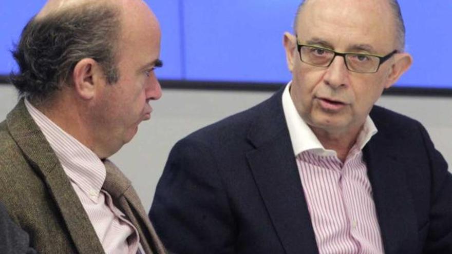 Luis de Guindos y Cristóbal Montoro, durante la reunión de Rajoy con los barones regionales del PP.