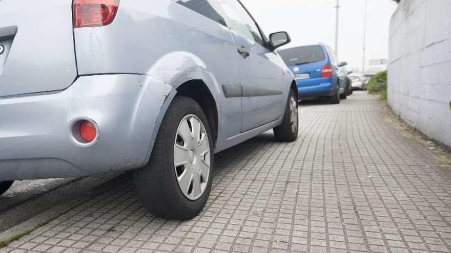 Varios coches, ayer, encima de la acera en As Xubias.