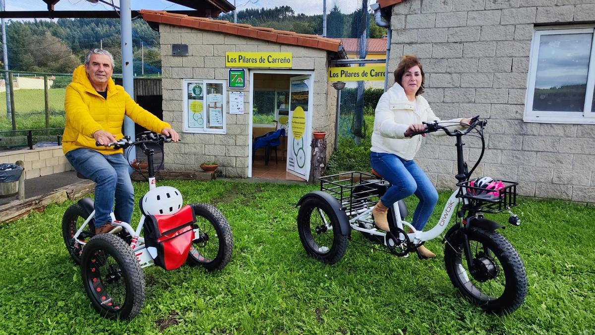 José Manuel Muñiz y Lourdes Bernabéu en dos bicicletas eléctricas delante de su local