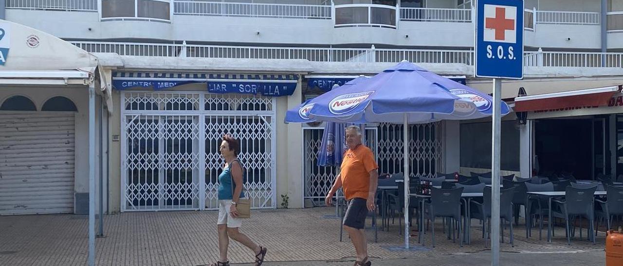 Dos personas pasean ayer por delante del consultorio auxiliar de Sorolla, cerrado en Peñíscola desde el año 2020.