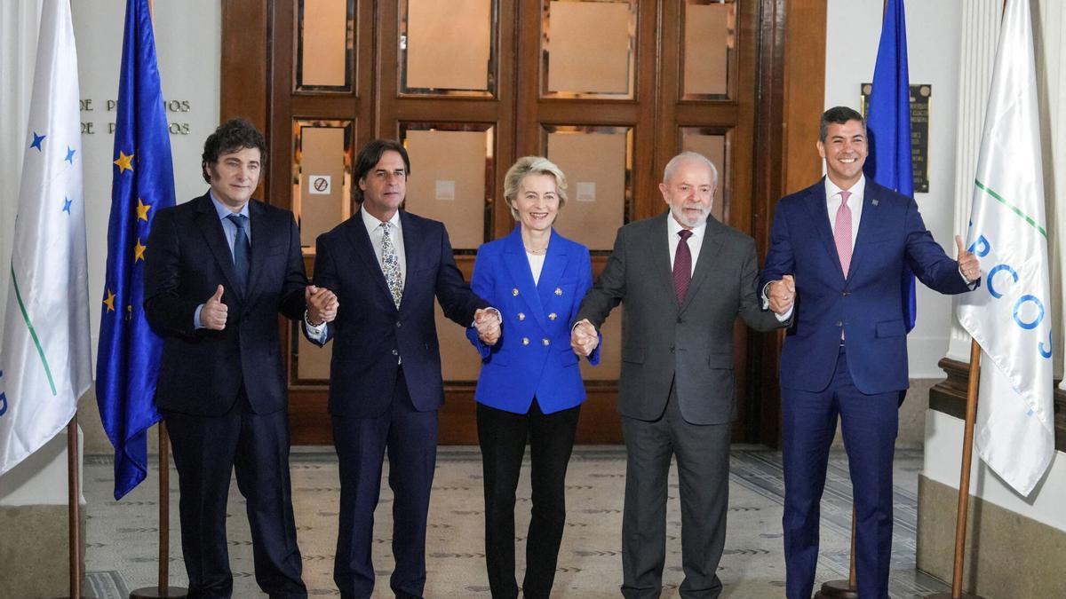 El presidente de Argentina, Javier Milei, el presidente de Uruguay, Luis Lacalle Pou, la presidenta de la Comisión Europea, Ursula von der Leyen, el presidente de Brasil, Luiz Inácio Lula da Silva, y el presidente de Paraguay, Santiago Peña, se toman de la mano mientras posan para una fotografía, en la Cumbre del Mercosur en Montevideo, Uruguay, el 6 de diciembre. , 2024.
