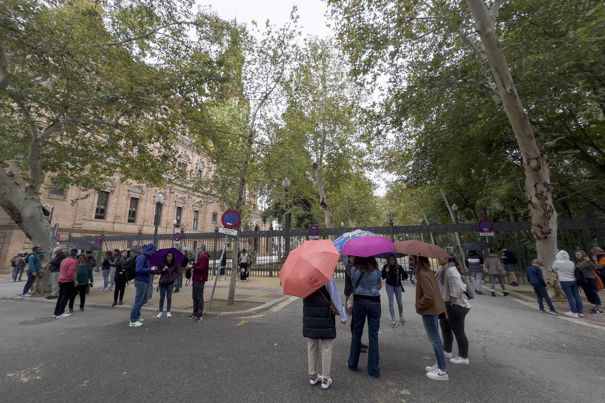 Decenas de turistas se agolpan a las puertas del parque de María Luisa, en Sevilla, cerrado en previsión de la llegada de la borrasca Bernard.