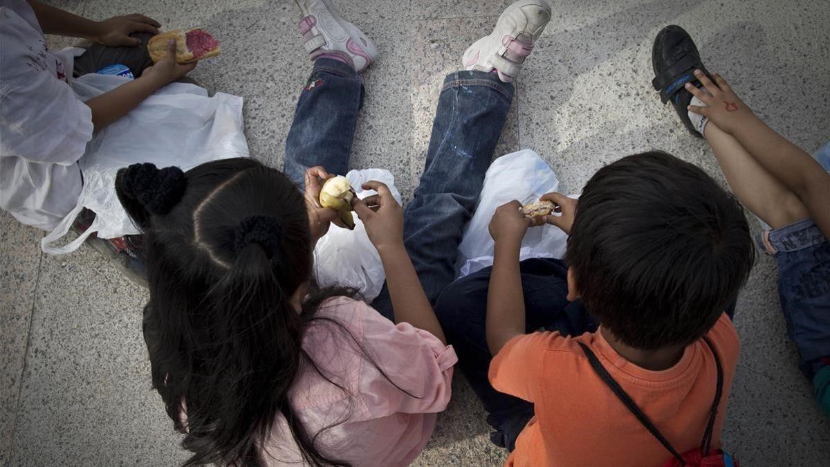 Unos niños, en la calle, a la hora de la merienda.