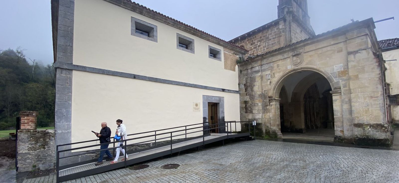 Dos personas, ayer, saliendo del centro de recepción de visitantes habilitado en la antigua sala capitular del monasterio maliayés. | J. A. O.