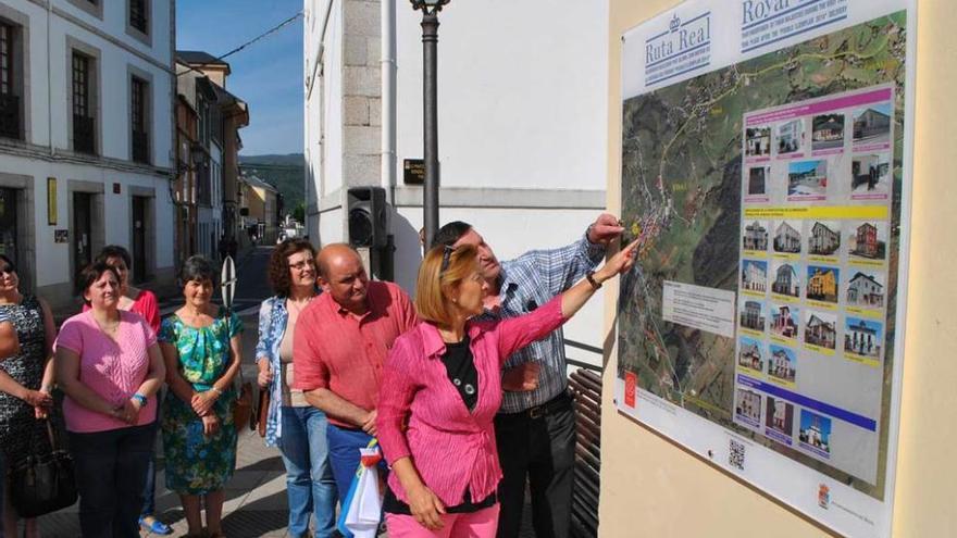 Cristina Álvarez Solís y el alcalde de Boal, a la derecha, examinan uno de los paneles que señalizan la ruta.