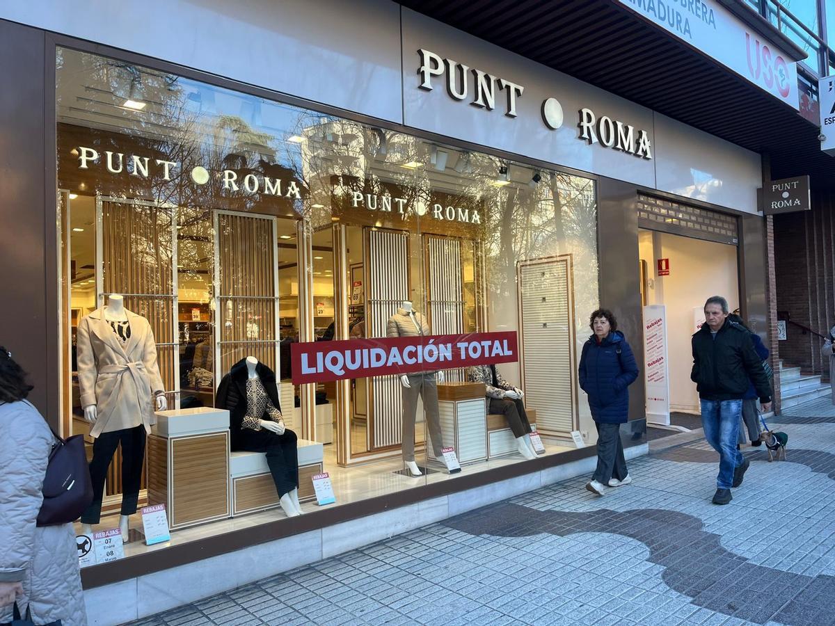 El cartel de 'Liquidación total' en el escaparate de Punt Roma.