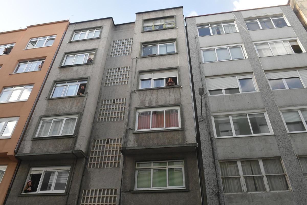 Vecinos asomados a las ventanas observando el operativo