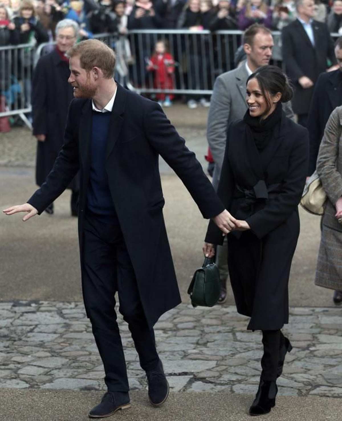 Meghan Markle con un look negro, y bolso verde, como nota de color