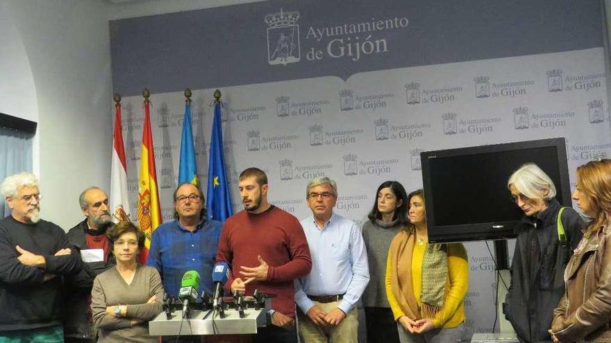 Ediles del gobierno y la oposición y representantes del entramado asociativo escuchan a Adrián Arias durante una comparecencia conjunta en el Ayuntamiento de Gijón.