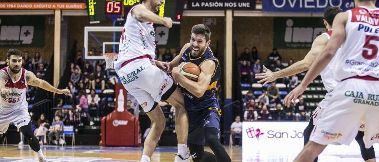 El base del Liberbank Oviedo Jorge Sanz, con el balón, defendido por Sergio Olmo, del Granada.