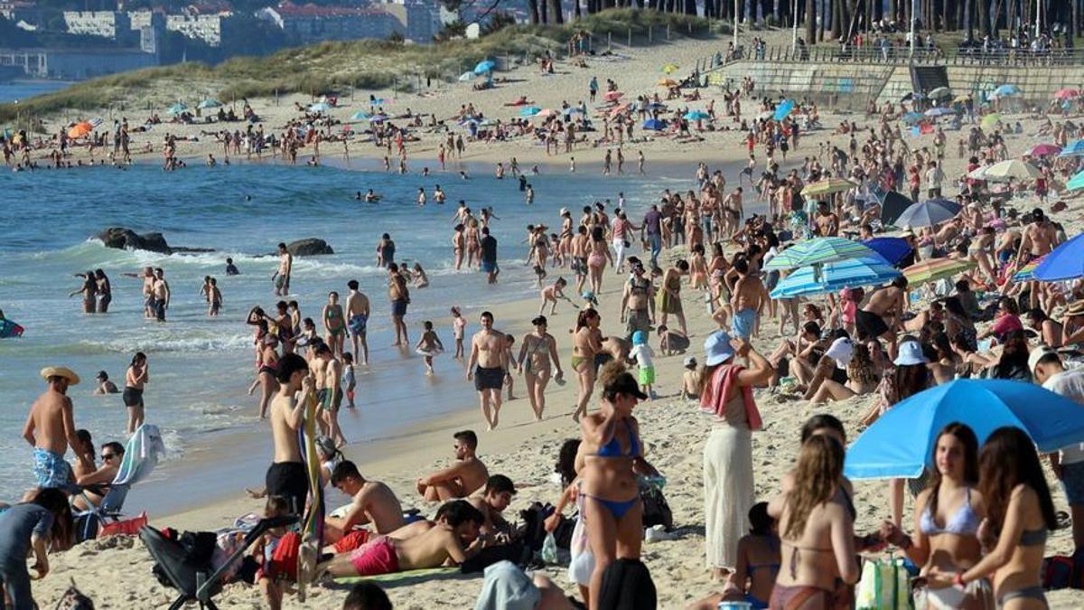Gente disfrutando de un día de calor en la playa viguesa de Samil. / MARTA G. BREA