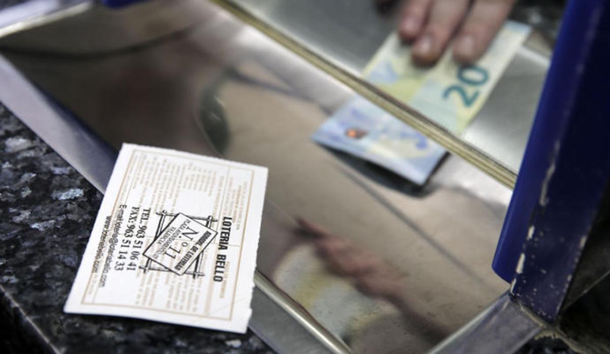 Un hombre compra un décimo de la Lotería del Niño.