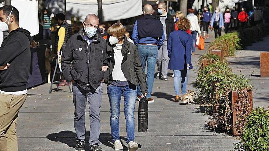 Gent passejant pel centre de Girona durant el confinament perimetral del cap de setmana