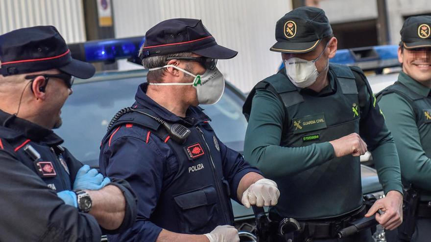 Un agente de la Ertzaintza y otro de la Guardia Civil se saludan con el codo.