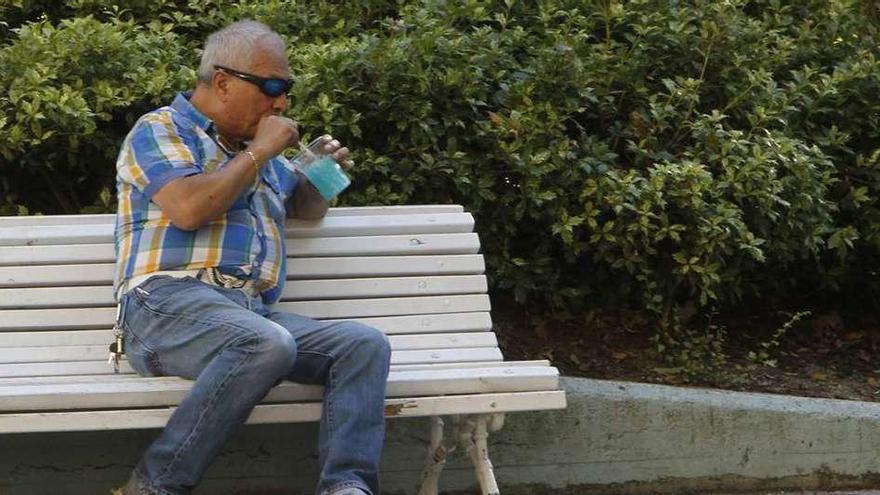 Un ciudadano palia los efectos del calor con granizado en el céntrico parque de San Lázaro. // Jesús Regal