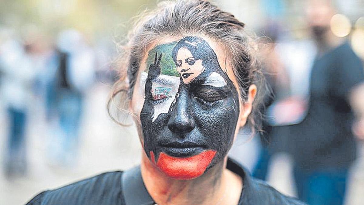 Rostro de una mujer con la cara pintada: Mujer, vida y libertad