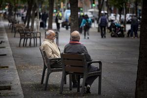 Dos jubilados sentados en un banco en Barcelona