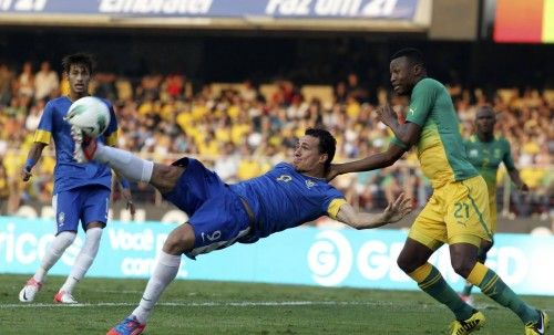 Brazil's Leandro Damiao kicks the ball next to South Africa's Syabonga Sangweni during their international friendly soccer match in Sao Paulo