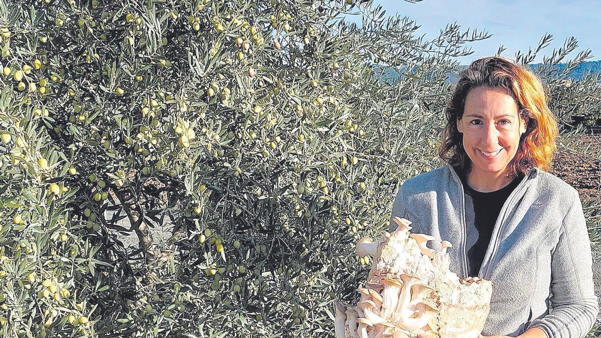 Entre olivares. María Rosas Alcántara porta una bolsa de sustrato de setas, esencial en sus cultivos.