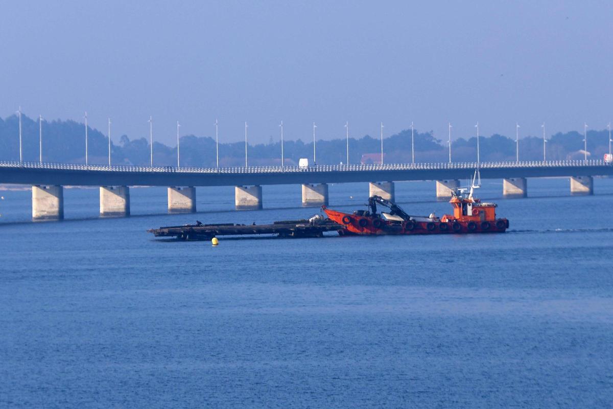 El traslado de una batea bajo el puente de A Illa.