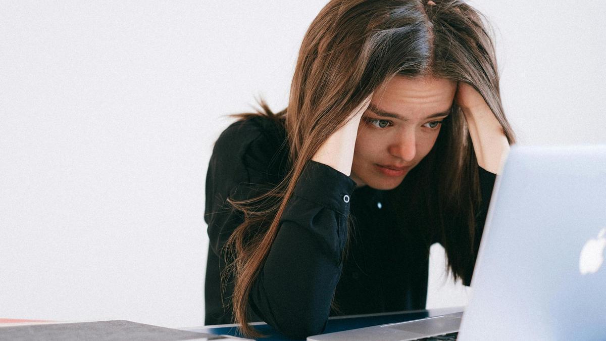Una joven preocupada tras buscar información en su portátil
