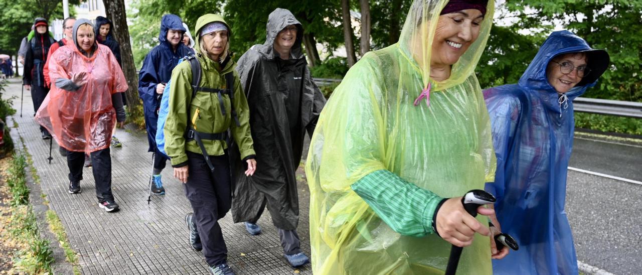 Un grupo de peregrinos desafía con buen humor a la lluvia.