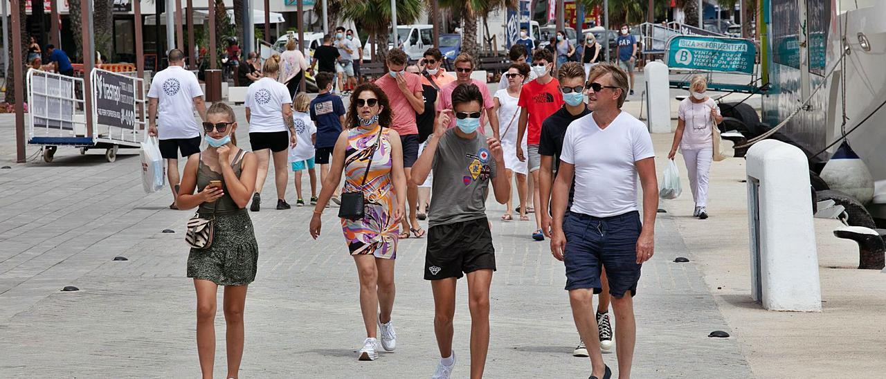 Turistas con y sin mascarilla en el puerto de Ibiza.