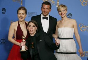 Amy Adams, Bradley Cooper i Jennifer Lawrence posen amb la productora de ’La gran estafa americana’ Megan Ellison, que sosté el Globus d’Or a la pel·lícula.