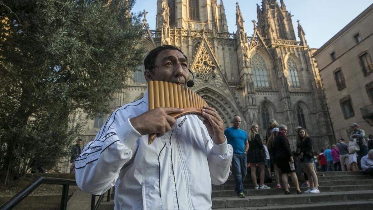 Un músico callejero ante la Catedral de Barcelona.