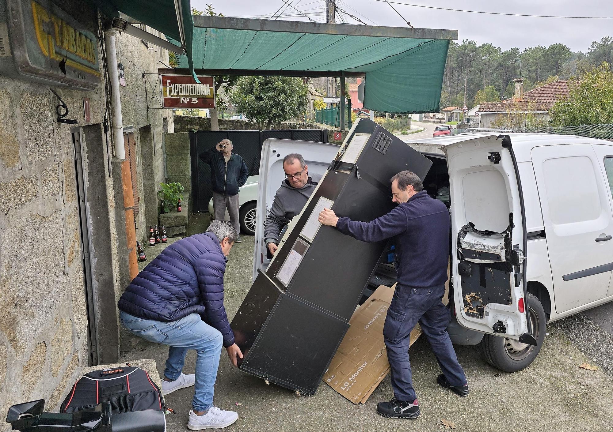 Retirada de la máquina tragaperras del bar estanco Lis que los atracadores rompieron esta mañana en Vilaza, Gondomar
