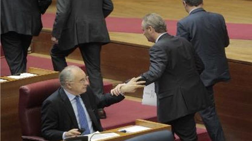 El presidente Fabra se despide de Blasco antes de salir del hemiciclo tras la sesión de control.