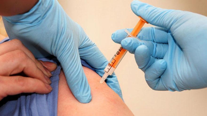 Un trabajador sanitario recibe la vacuna contra la gripe A