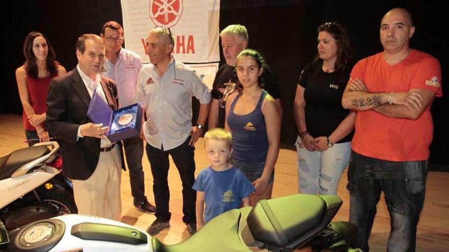 Los padres de Lorenzo (4º i) y Dani Rivas (5º i) y miembros de Motoclub Galicia entregan la placa al alcalde. // J.L.