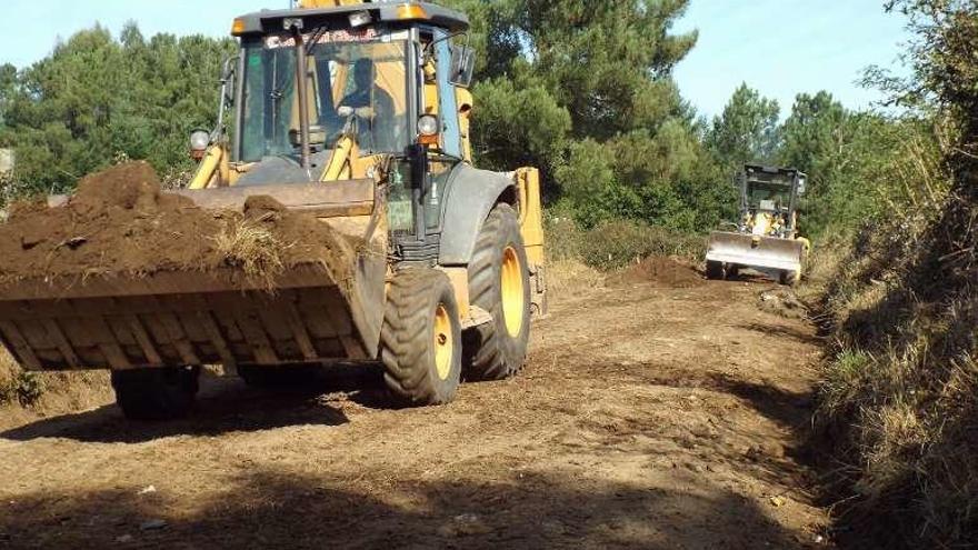 Un grupo de grúas retiran tierra en el acceso a varias fincas en Laro.