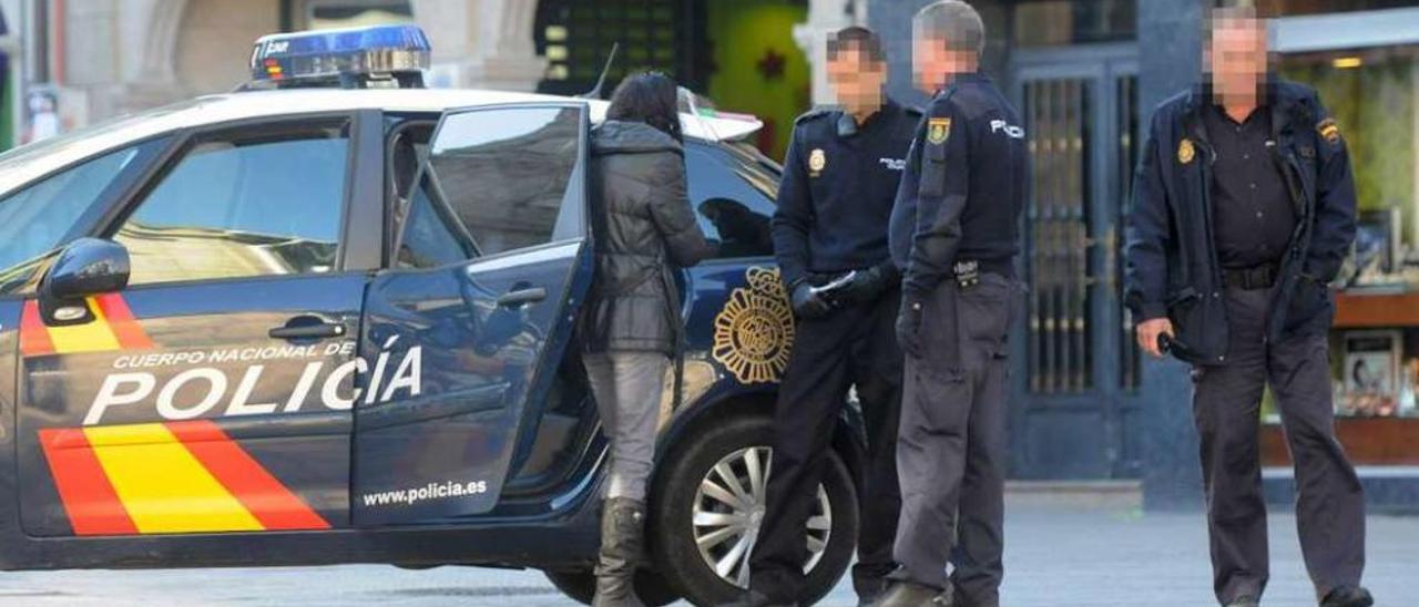 Policías nacionales tras sorprender a la autora de un hurto en la zona comercial de la ciudad. // G. Santos