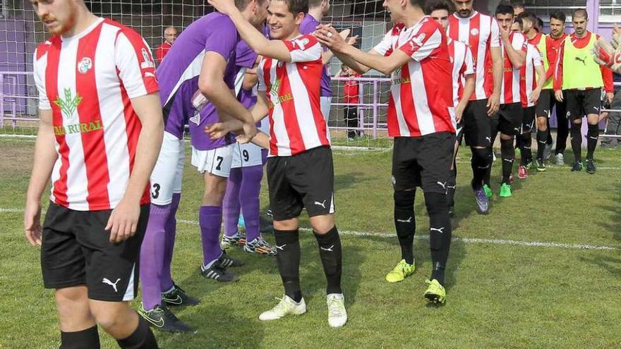 Los jugadores rojiblancos saludan a sus rivales, ayer en La Bañeza.