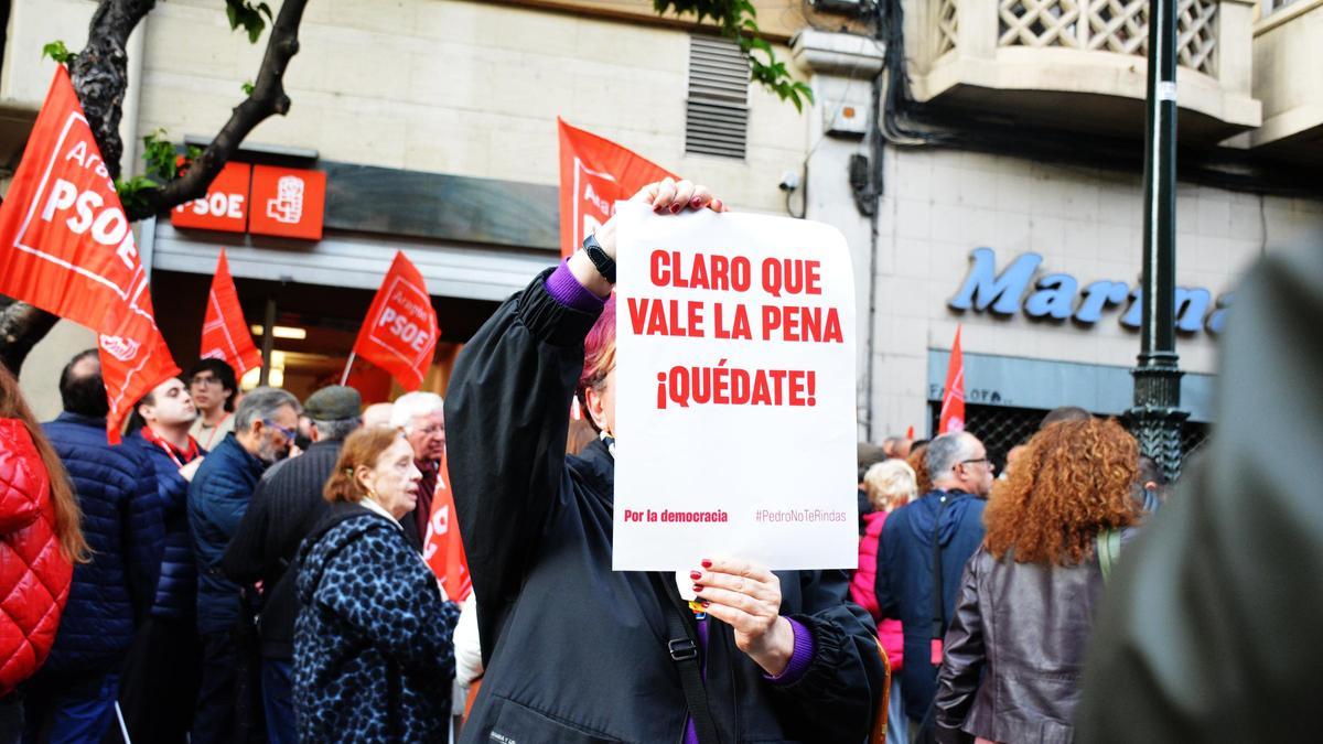 Una militante socialista muestra un cartel de apoyo a Sánchez, el pasado jueves, frente a la sede de Zaragoza.