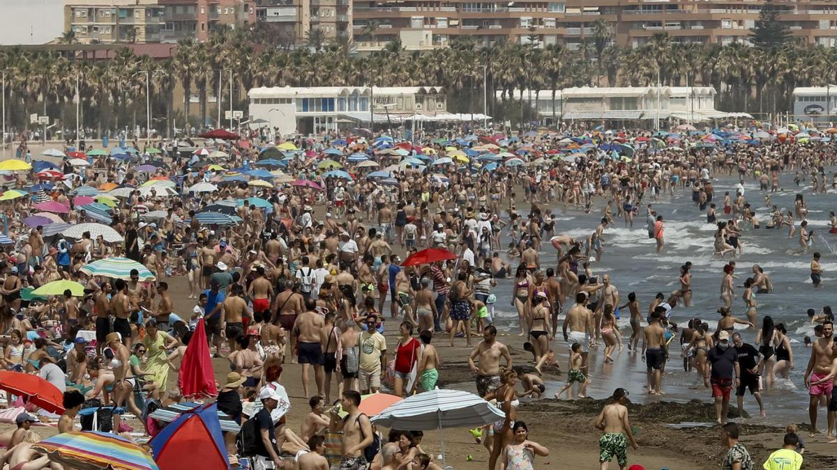 Playa de València, abarrotada en el último domingo de la ‘primavera climatológica’. | EFE/JUAN CARLOS CÁRDENAS