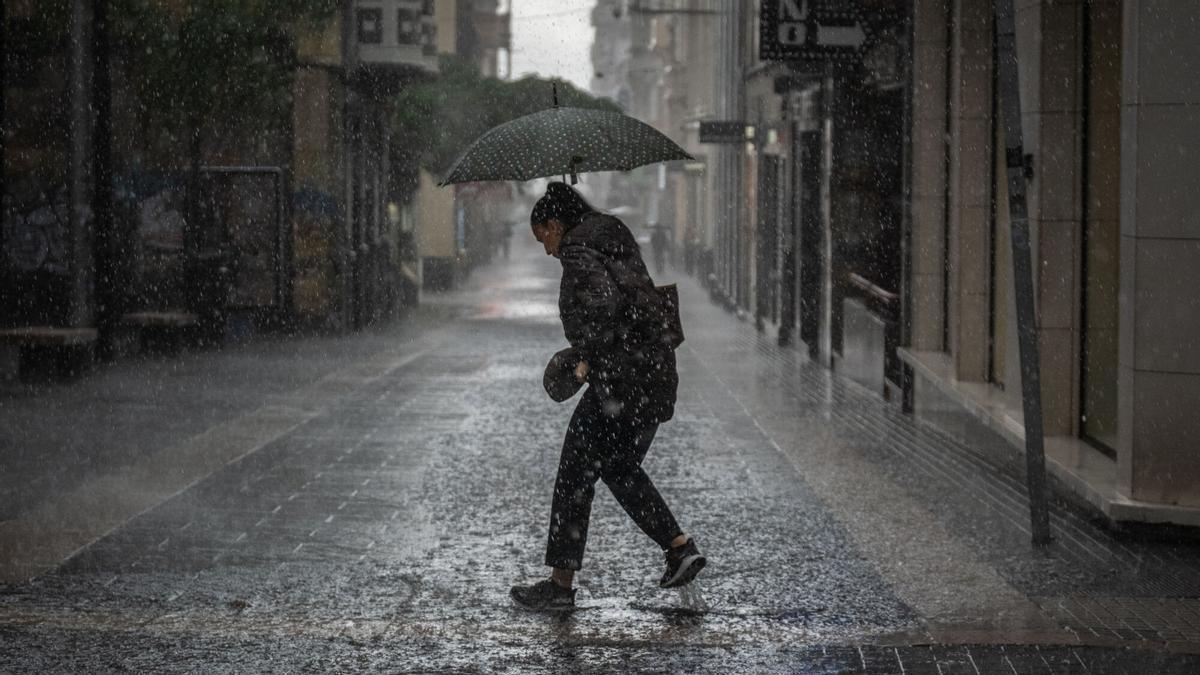 Una mujer pasea bajo la intensa lluvia de Therese por Santa Cruz de Tenerife.