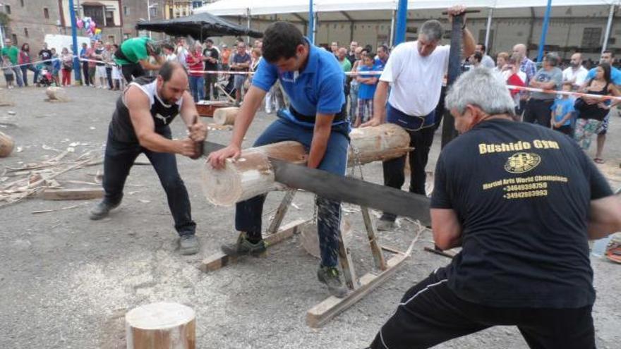 Integrantes del equipo «Los Amigos», de Cantabria, ayer, cortando un tronco con el hachu ante el público.