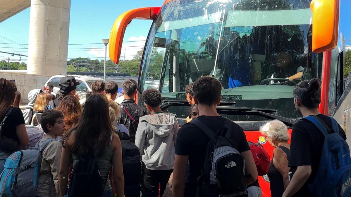 Diversos passatgers fent cua per pujar a un bus.