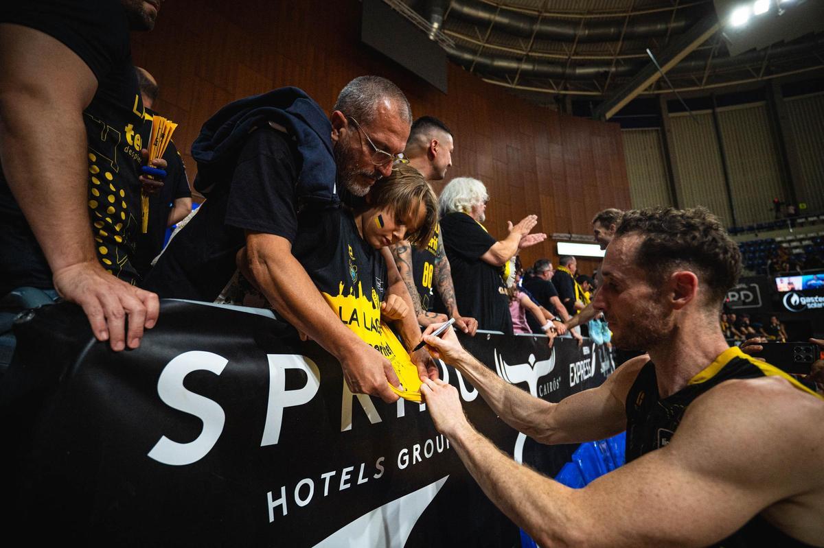 Marcelinho Huertas le firma la camiseta a un aficionado al término del partido del sábado.