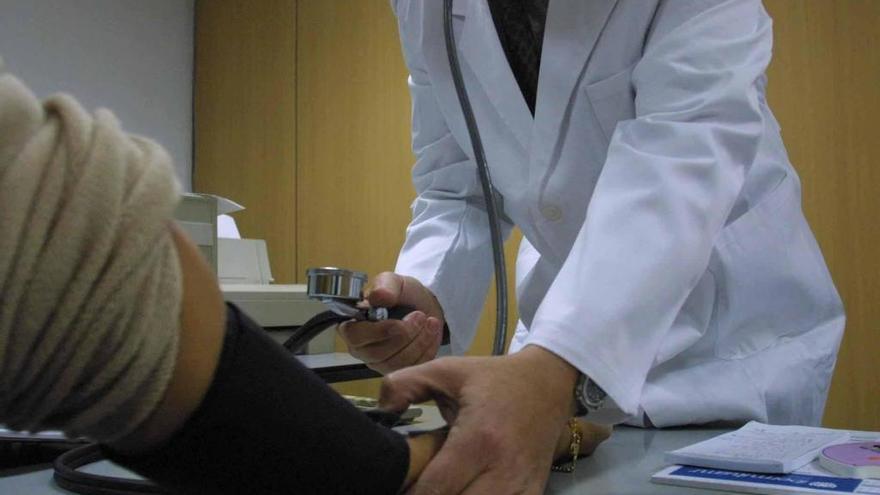 Imagen de archivo de un médico midiendo la tensión arterial de un paciente.